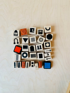 flat lay of detail of 28 individual wood-backed robot stamps 