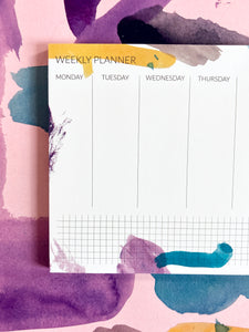 detail colorful weekly planner with brush pen pattern and abstract pattern gift wrap in the background