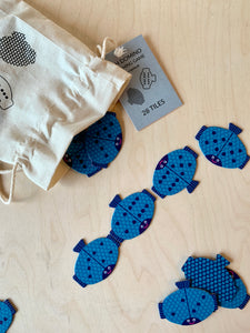 flatlay of fish shaped domino matching game with cotton bag